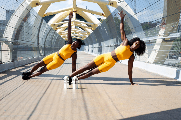 two black women holding side planks