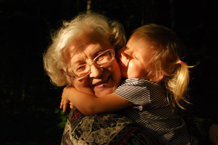 older woman being hugged by young girl